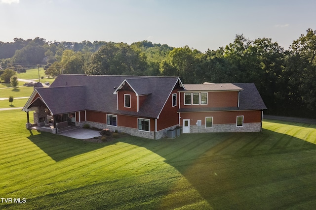 exterior space featuring a patio area, a front yard, and stone siding