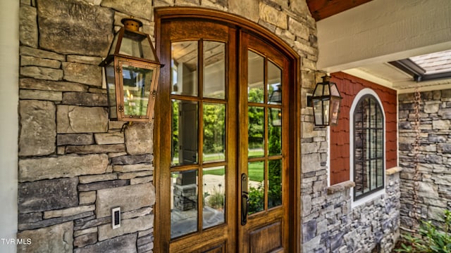 property entrance featuring french doors and stone siding
