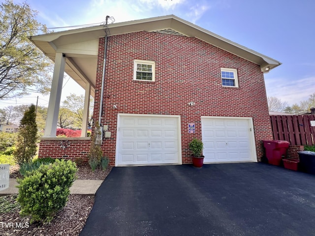 2215 Knob Creek Rd, Johnson City, TN 37604 - view of property exterior with an attached garage, driveway, fence, and brick siding