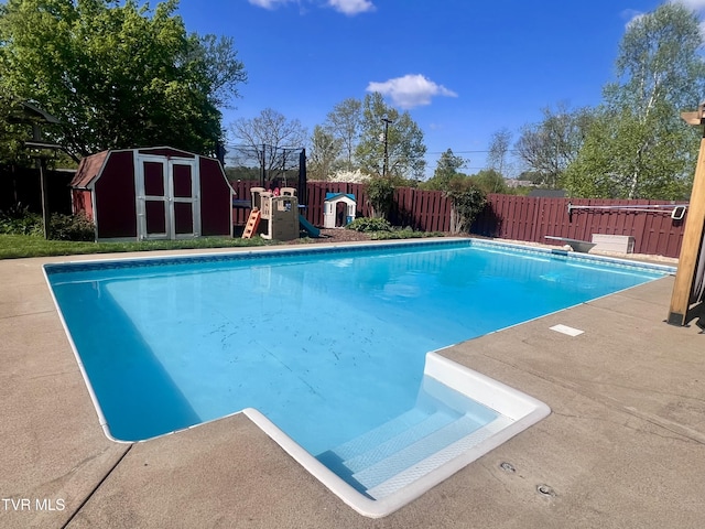 2215 Knob Creek Rd, Johnson City, TN 37604 - view of swimming pool featuring a diving board, a storage shed, a fenced backyard, an outdoor structure, and a fenced in pool