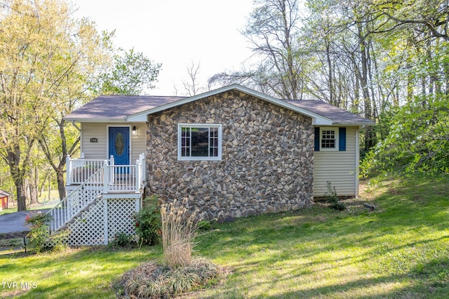 ranch-style house featuring a front lawn and stone siding