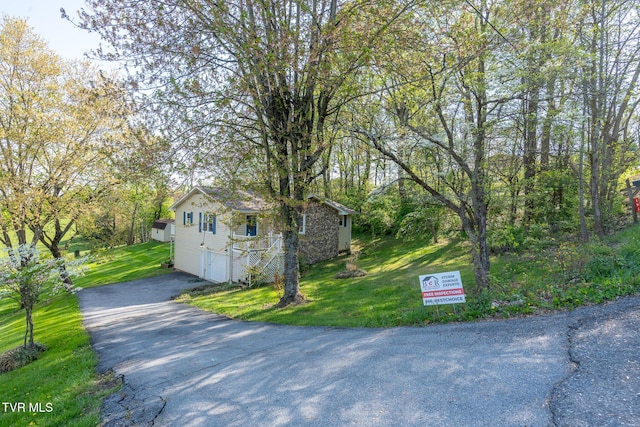 view of home's exterior featuring a yard, an attached garage, and driveway