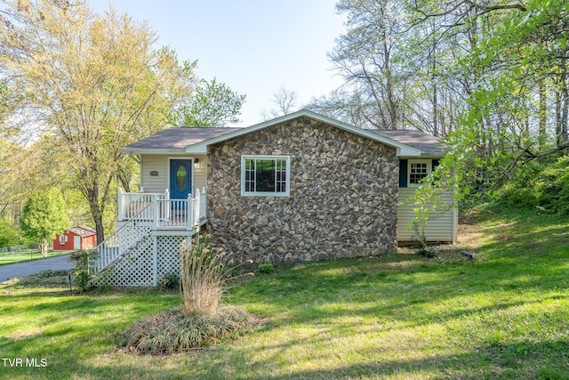 view of front facade featuring a front yard and stone siding
