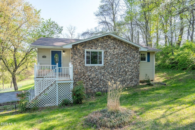 view of front facade featuring stone siding and a front lawn