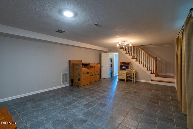 below grade area featuring visible vents, baseboards, a textured ceiling, and stairs