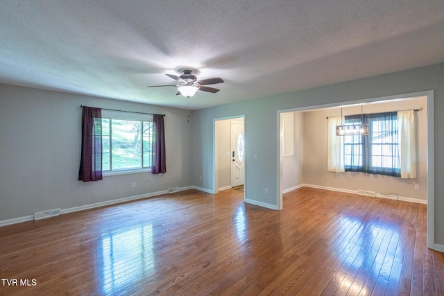 unfurnished bedroom with wood finished floors, ceiling fan, baseboards, and visible vents