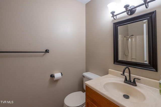 bathroom with toilet, a shower, and vanity