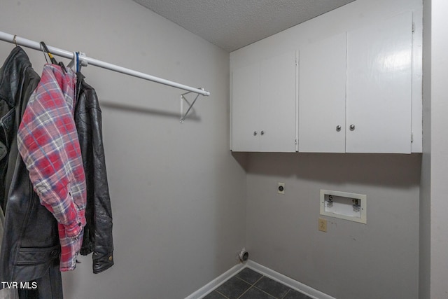 laundry area featuring dark tile patterned floors, electric dryer hookup, baseboards, hookup for a washing machine, and cabinet space