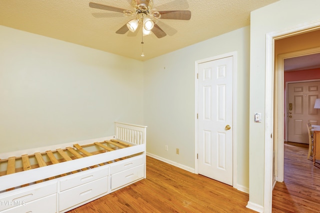 unfurnished bedroom with light wood-type flooring, baseboards, and a ceiling fan