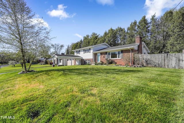 610 Pine Hill Rd, Elizabethton, TN 37643 - tri-level home featuring a garage, a chimney, fence, brick siding, and a front lawn