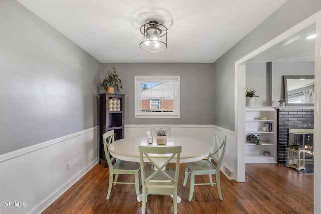 610 Pine Hill Rd, Elizabethton, TN 37643 - dining space with wood finished floors, a fireplace, wainscoting, and visible vents