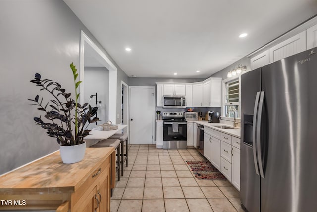610 Pine Hill Rd, Elizabethton, TN 37643 - kitchen with a sink, white cabinetry, wood counters, stainless steel appliances, and light tile patterned flooring