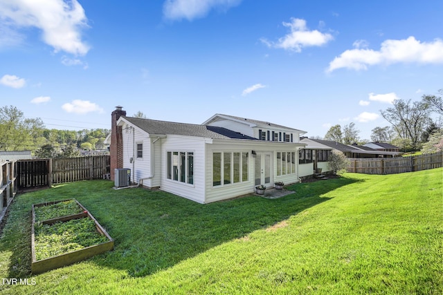 610 Pine Hill Rd, Elizabethton, TN 37643 - back of property with a vegetable garden, a fenced backyard, a lawn, a chimney, and central AC unit