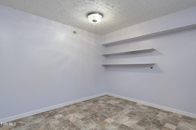 spare room with visible vents, baseboards, and stone finish floor