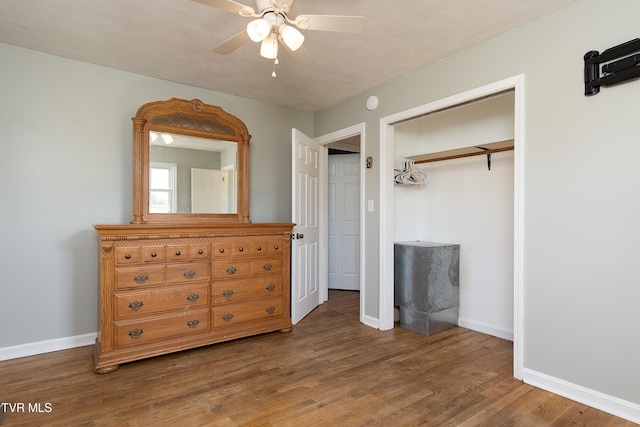 bedroom with a closet, baseboards, ceiling fan, and wood finished floors
