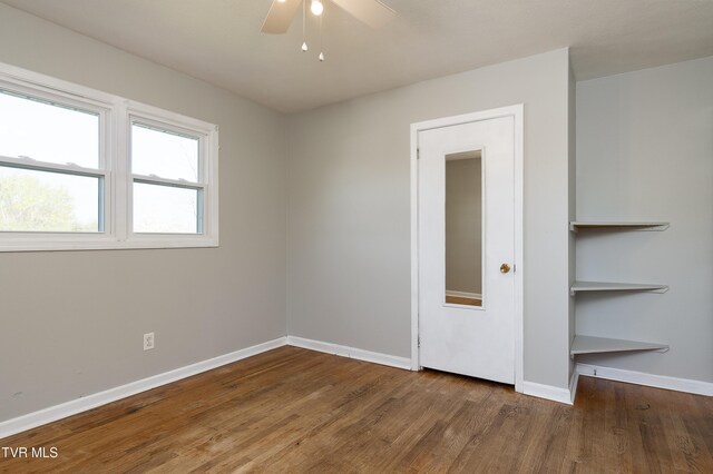 empty room featuring baseboards, ceiling fan, and wood finished floors