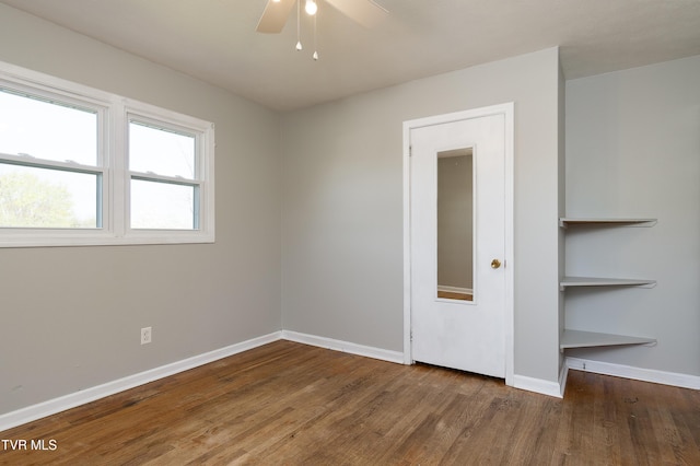 unfurnished room with baseboards, ceiling fan, and wood finished floors