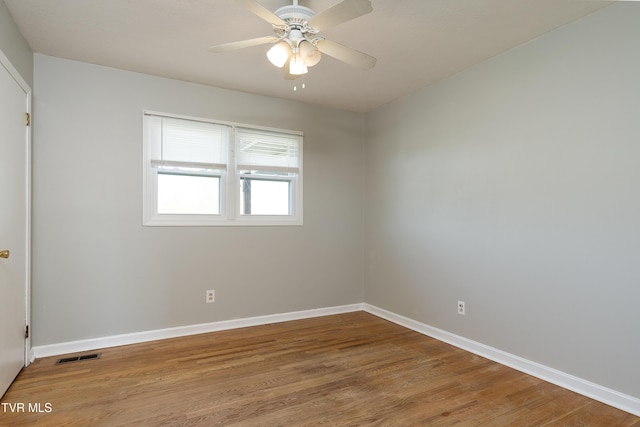 unfurnished room with wood finished floors, baseboards, a ceiling fan, and visible vents