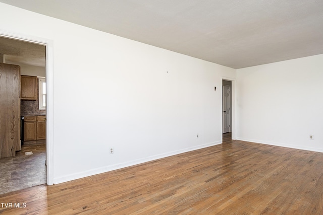 empty room featuring light wood finished floors and baseboards
