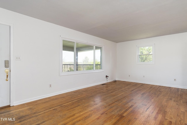 empty room featuring baseboards and wood finished floors