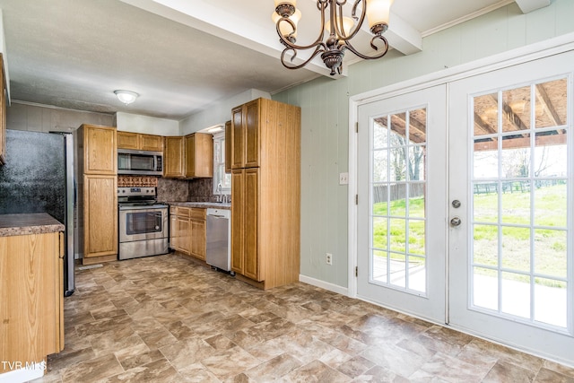 kitchen featuring a chandelier, french doors, stone finish floor, brown cabinetry, and appliances with stainless steel finishes