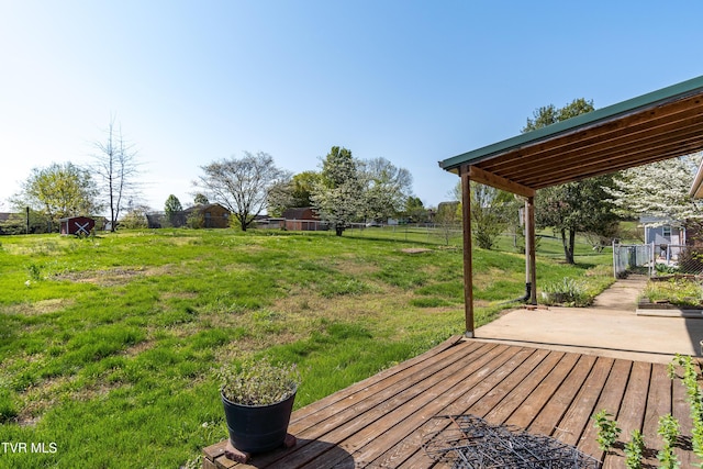 wooden terrace featuring a yard and fence