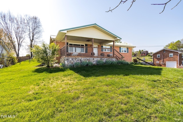 view of front of house with a front yard, brick siding, and covered porch