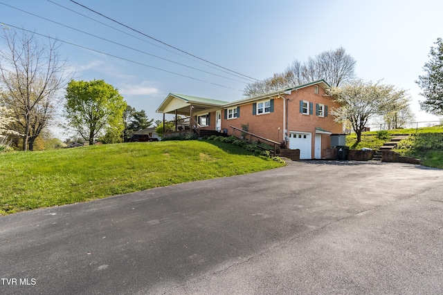 view of home's exterior featuring a lawn, aphalt driveway, brick siding, and an attached garage