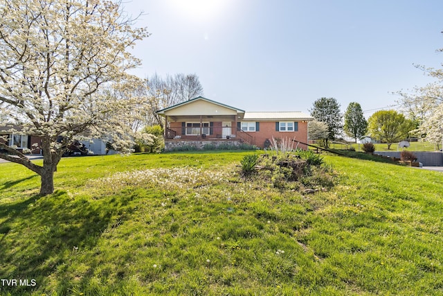 ranch-style house featuring a front yard, brick siding, and covered porch