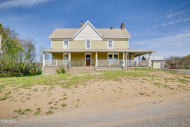 country-style home with a porch and a chimney