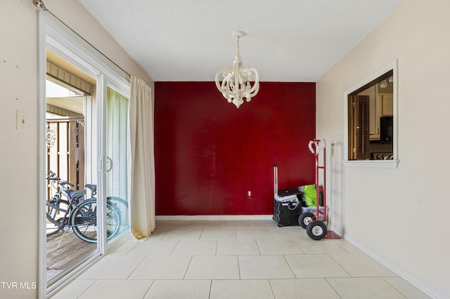 1023 Pebble Dr, Bristol, VA 24201 - unfurnished dining area with a chandelier, tile patterned flooring, an accent wall, and baseboards