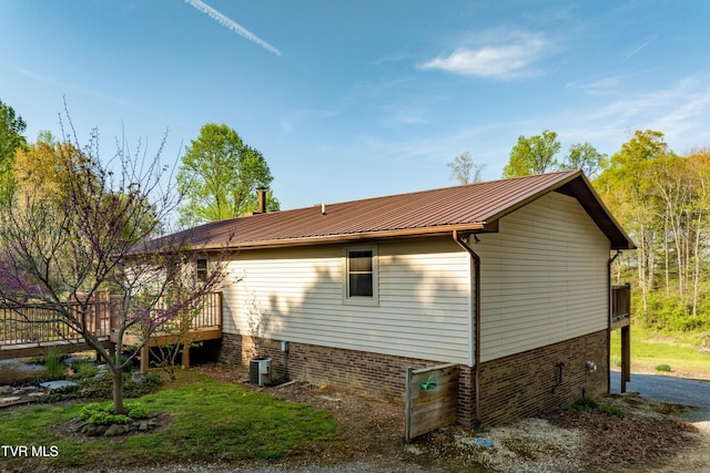view of property exterior featuring a deck and metal roof