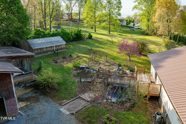 view of yard featuring central AC unit, an outdoor structure, a greenhouse, and a wooden deck