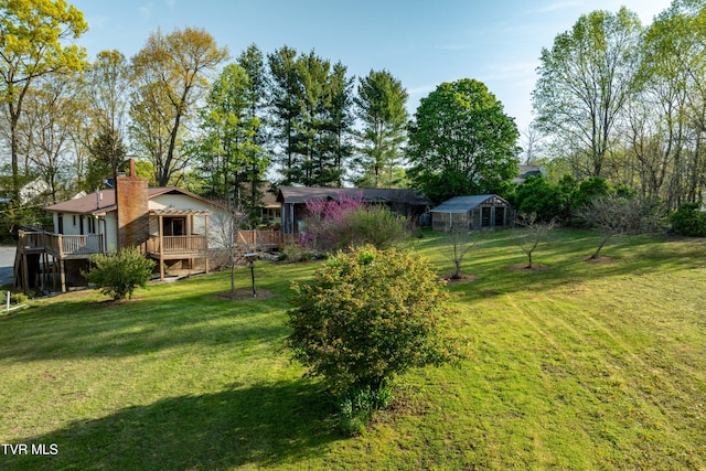 view of yard featuring an outbuilding, a wooden deck, and an exterior structure