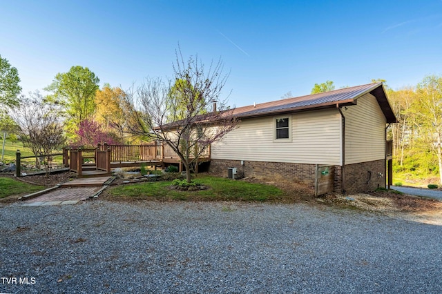 exterior space featuring metal roof and a wooden deck