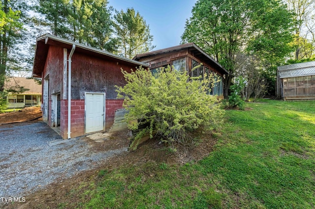 view of outdoor structure featuring a garage and gravel driveway