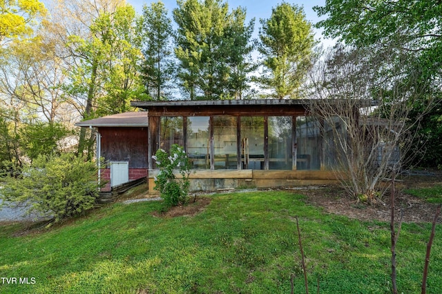 rear view of house with a yard and a sunroom