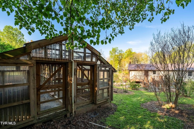 exterior space featuring an outbuilding, a lawn, and an exterior structure