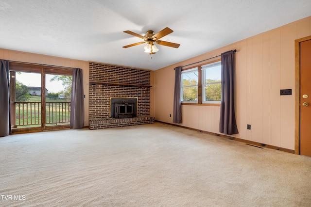 unfurnished living room with carpet flooring, a ceiling fan, plenty of natural light, and visible vents