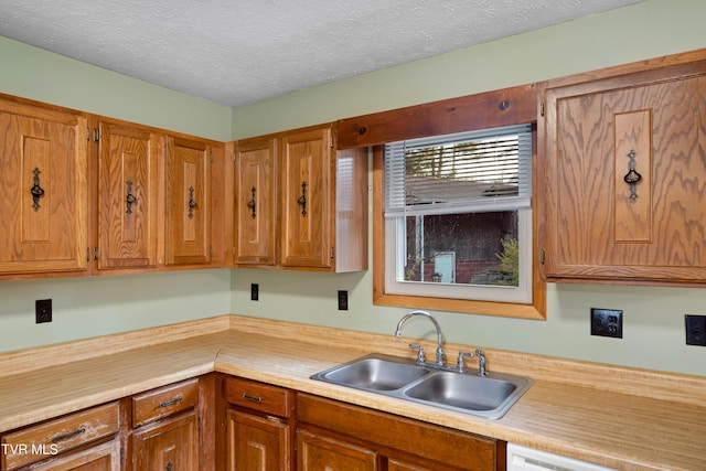 kitchen with a sink, light countertops, and brown cabinets