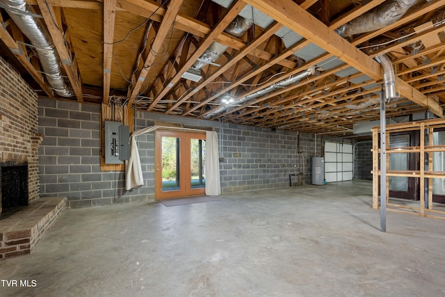 basement featuring water heater, concrete block wall, and electric panel
