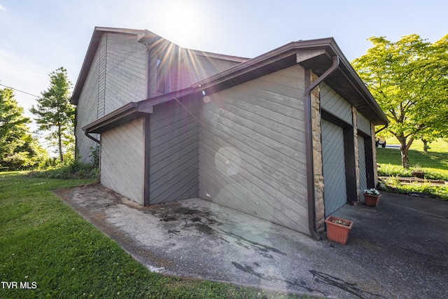 view of side of property with a lawn and a garage