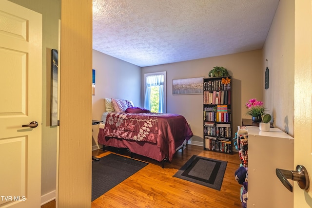 bedroom featuring a textured ceiling and wood finished floors