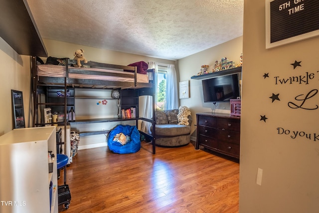 bedroom featuring wood finished floors and a textured ceiling