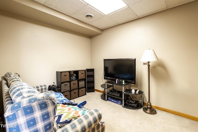 living area featuring carpet floors, baseboards, and a paneled ceiling