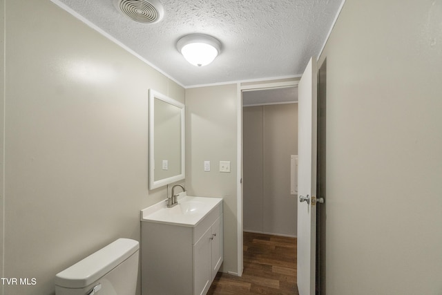 810 Sugar Bowl Rd, Chuckey, TN 37641 - half bathroom featuring a textured ceiling, vanity, visible vents, toilet, and wood finished floors
