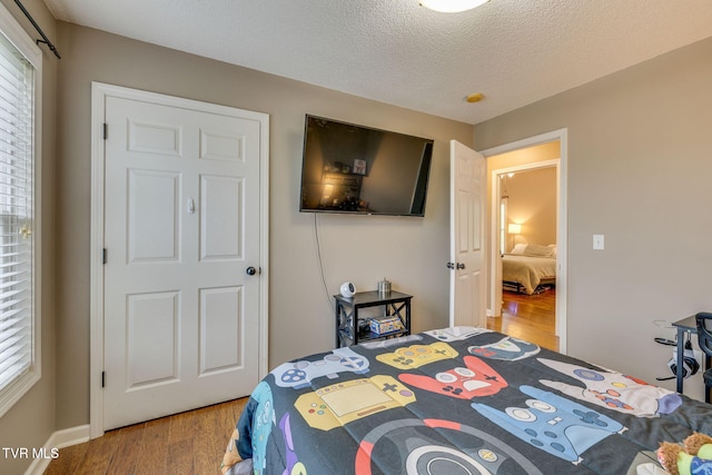 bedroom featuring a textured ceiling and wood finished floors