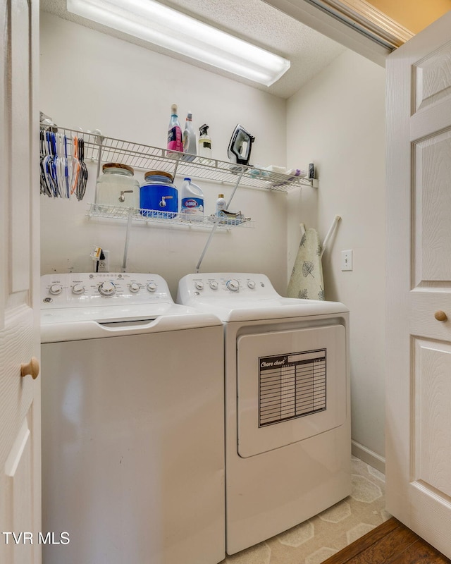 clothes washing area featuring wood finished floors, washer and clothes dryer, and laundry area