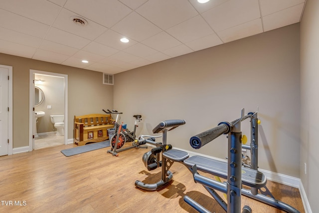 workout area with visible vents, baseboards, recessed lighting, wood finished floors, and a paneled ceiling