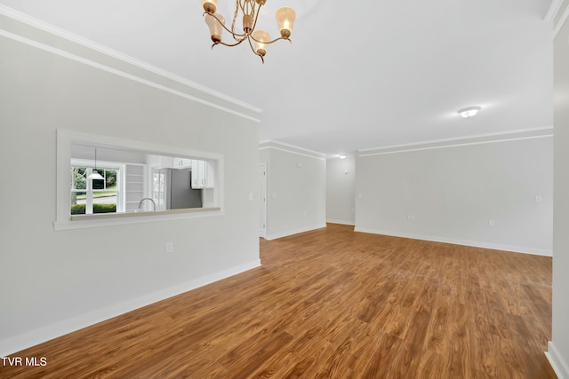 211 University Pkwy Unit 5, Johnson City, TN 37604 - unfurnished living room featuring baseboards, a notable chandelier, a sink, ornamental molding, and wood finished floors